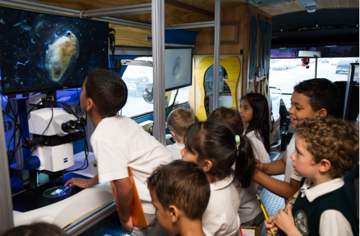 Students enjoy working with a microscope on the BioBus. 