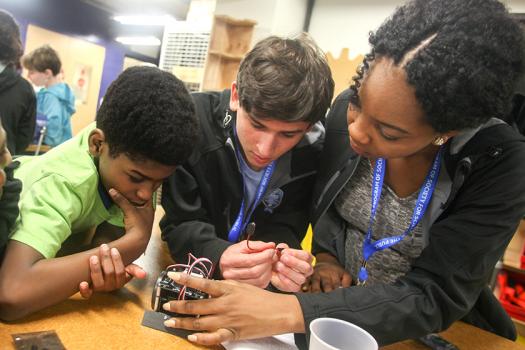 Thomas Colburn (middle) and another Intel STS 2016 finalist help students in Washington, D.C. create circuits.