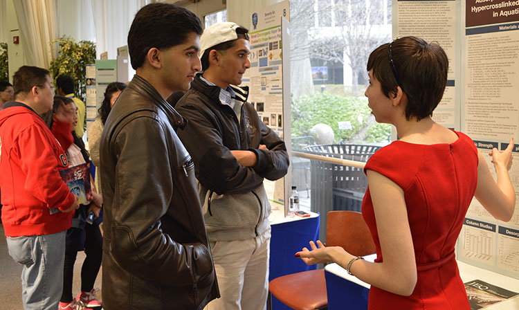 Maria Elena Grimmett explains her project to members of the public.