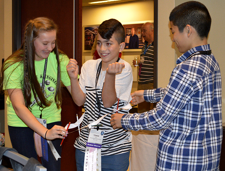Members of the silver team cut one sheet of paper creatively and were able to fit their team member through. Members of the silver team cut one sheet of paper creatively and were able to fit their team member through.