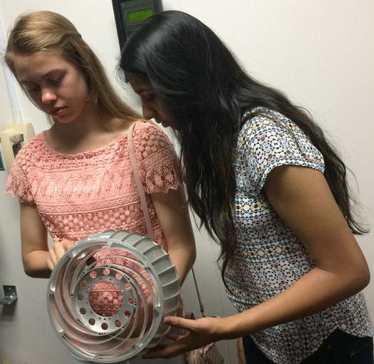 Nicky and Tiasha hold a spare wheel from Curiosity at JPL.