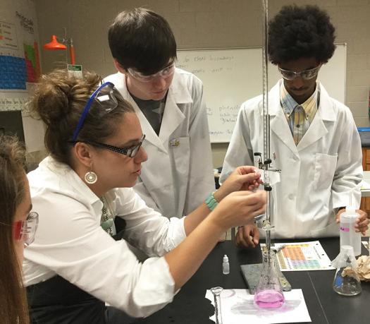 Elizabeth helps her students with a lab experiment.