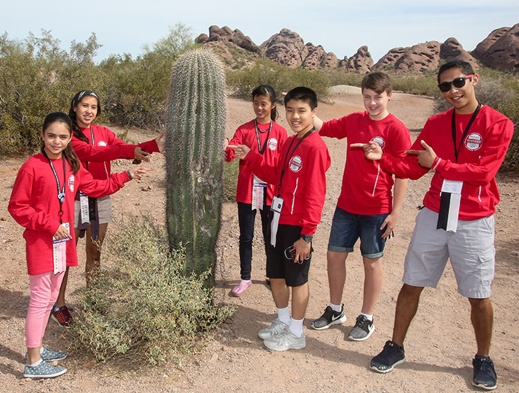 A group of delegates surround a saguaro cactus on their tour of the Desert Botanical Garden.