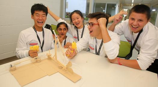 The white team celebrates after making a robotic blue crab arm.