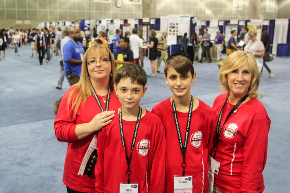 Israeli delegates Shai Grizek and Omri Mishaly with Paula Golden and Ilanit Drori from Broadcom in the Intel ISEF finalist hall.