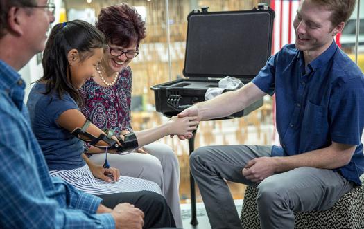 Easton presents Momo with her new prosthetic arm.