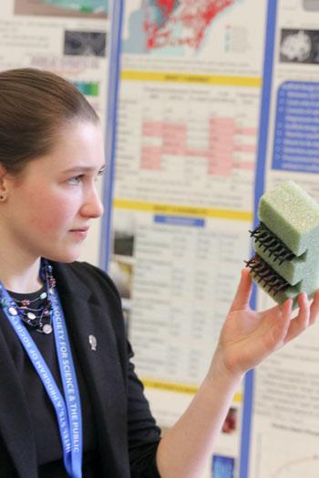 Paige holds the housing for her filter. Made of foam and two hair clips, it can be suspended in water where the filters can capture phosphorus.