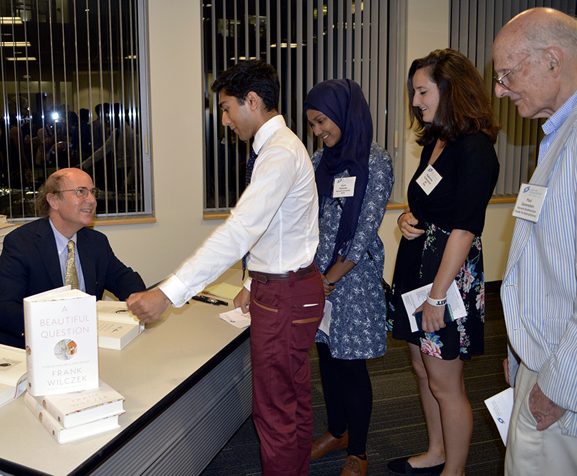 STS alumni Shaun Datta, Zarin Rahman, and Kathy Camenzind and Society guest Dr. Paul Gorenstein (far right) gather to have Frank Wilczek sign copies of his new book.