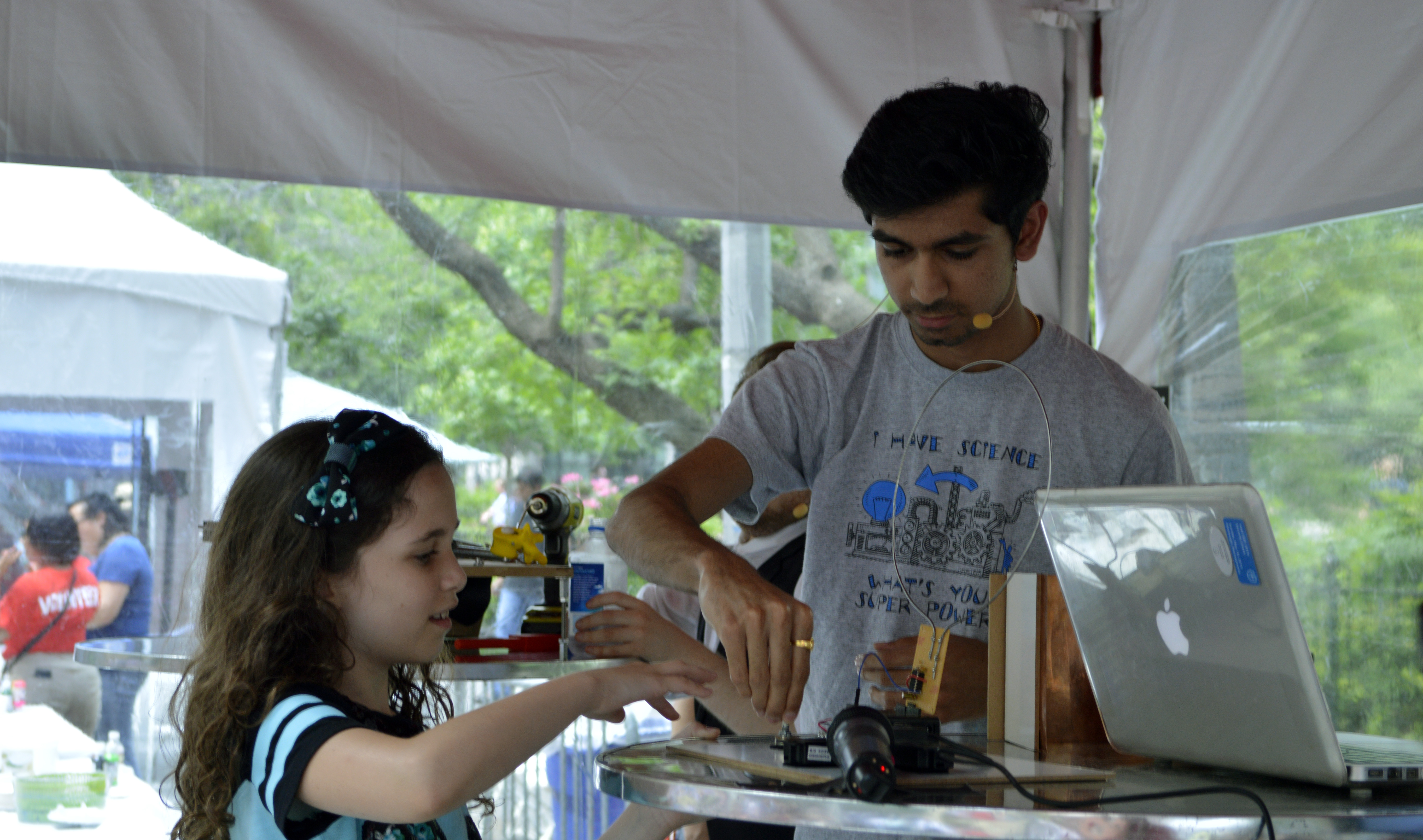 Eswar sharing his design with a curious young spectator.