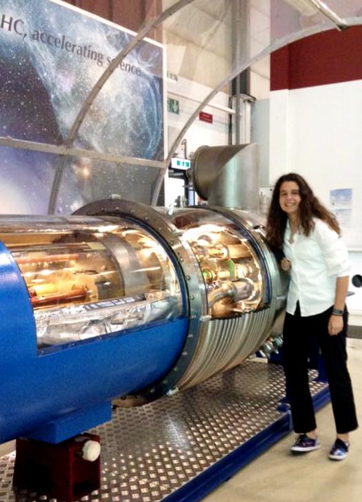 Francisca stands next to a model of LHC tubes.