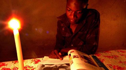 Students often have to read by candlelight to complete their homework due to a shortage of electricity in Zimbabwe.