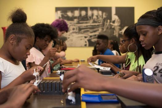 SAFE students form an assembly line to put together crafts