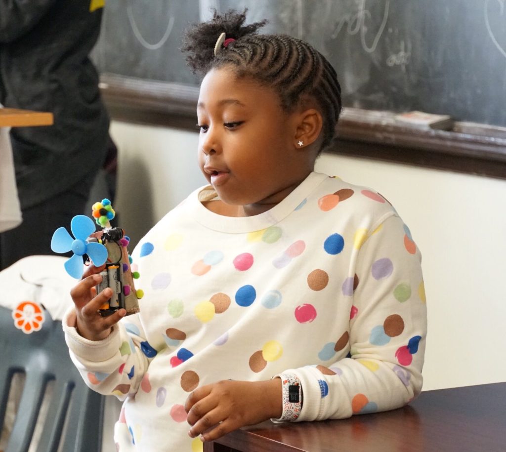 A participant presents her invention to an audience of family members and peers.
PHOTO COURTESY OF ELECTRIC GIRLS.