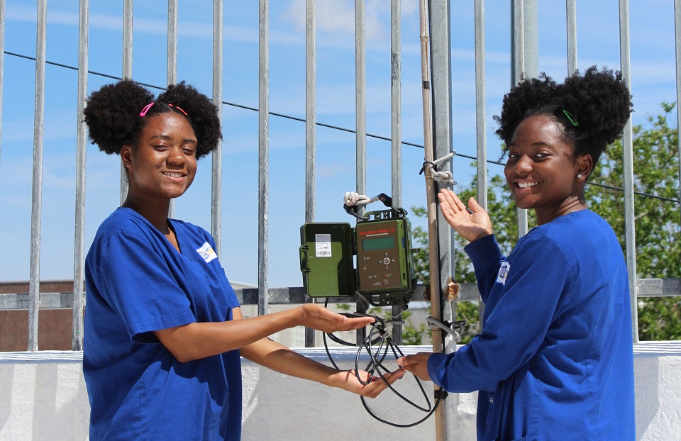 Two of Samuel's students with bat monitoring equipment on their school’s roof.