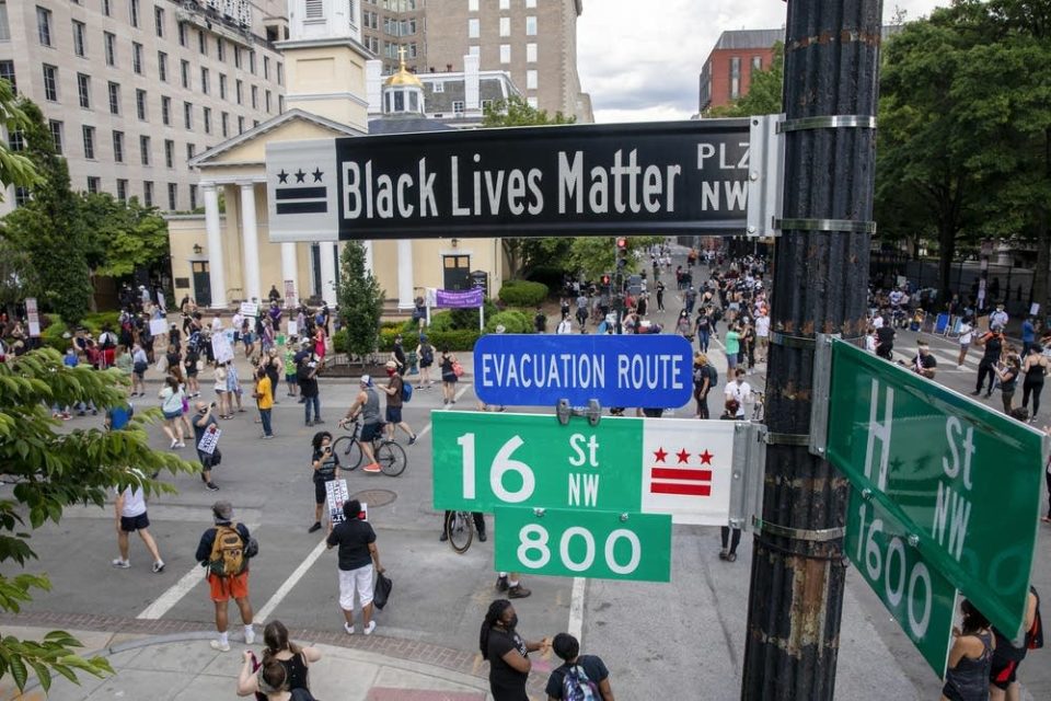 People walk down 16th Street after volunteers, with permission from the city, painted 'Black Lives Matter' on the street near the White House on June 5, 2020, in Washington, D.C. After seven days of protests in D.C. over the death of George Floyd, D.C. Mayor Muriel Bowser has renamed that section of 16th Street 'Black Lives Matter Plaza.'