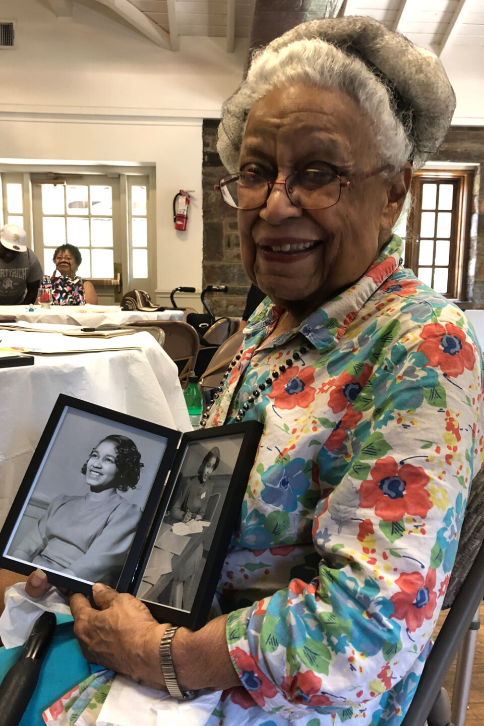 Notable Alumni - Nancy Durant Edmonds at her 90th birthday party, holding pictures of herself from the 1944 STS.
