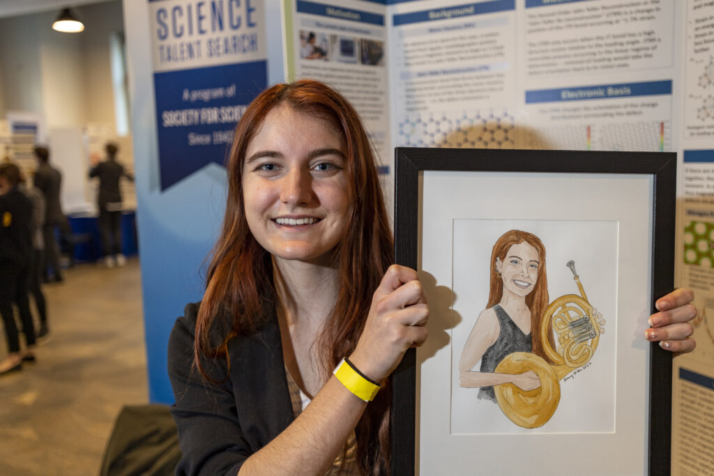 Claire Andreasen poses with her portrait at Public Day