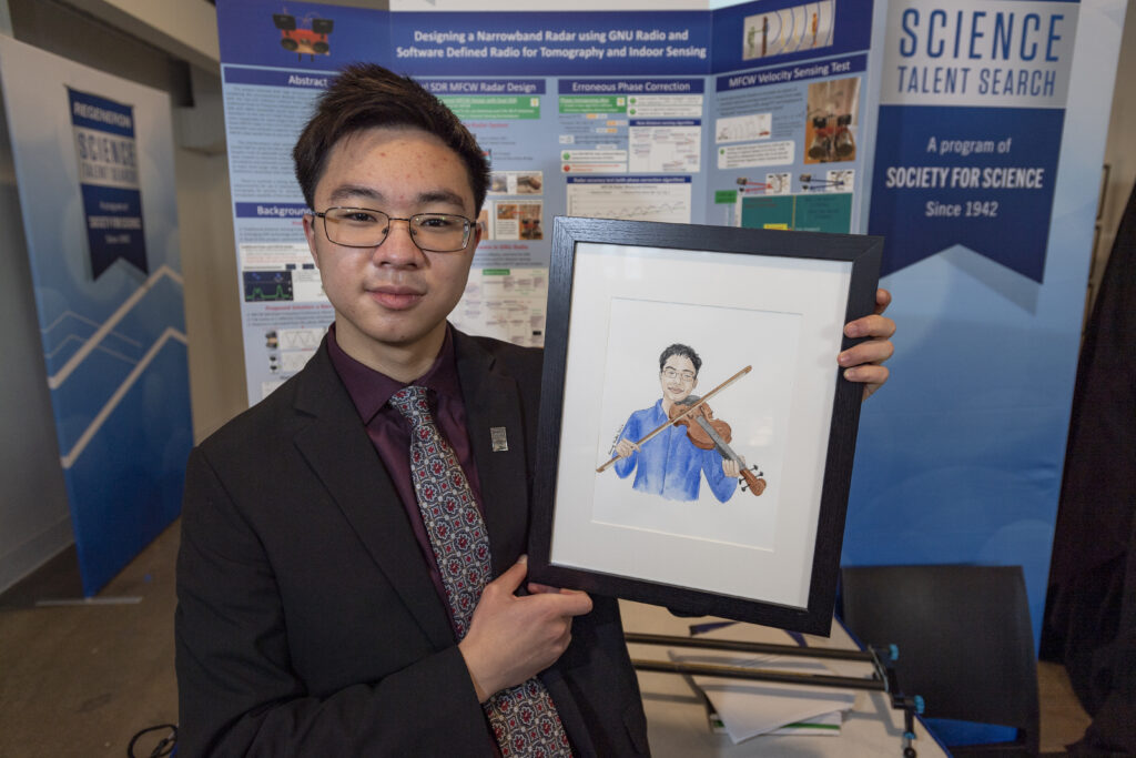 Victor Cai poses with his self portrait during Public Day