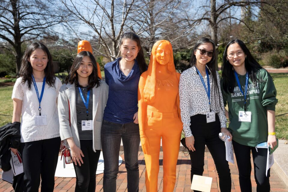 2022 Science Talent Search finalists pose with an If/Then statue of an STS alumna.