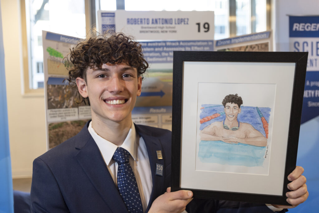 Roberto Lopez poses with his self portrait during Public Day