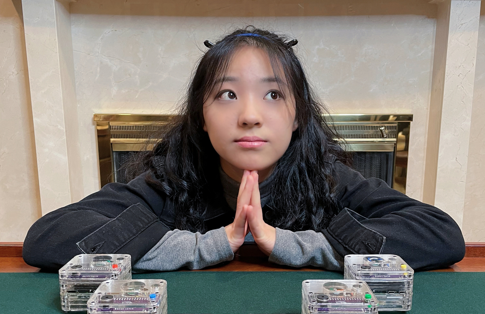 Vivien He sits with four Qube devices on a table in front of her