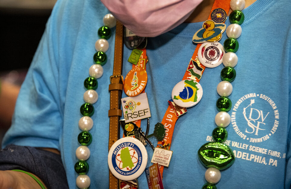 2022 Regeneron ISEF Finalist wears Mardi Gras beads and pins on their ISEF badge