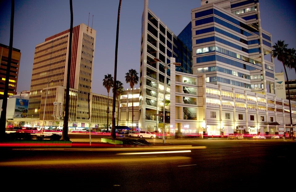 A street in Harare at dusk, with the blur of traffic passing in the foreground