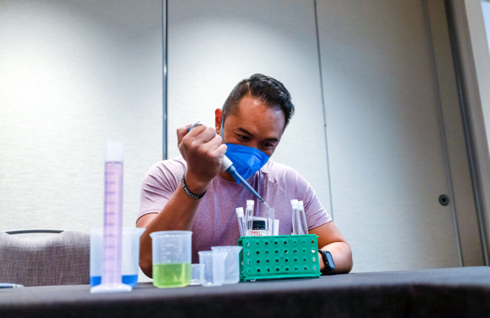 A teacher works on a pH testing kit at the 2022 Middle School Research Teachers Conference.