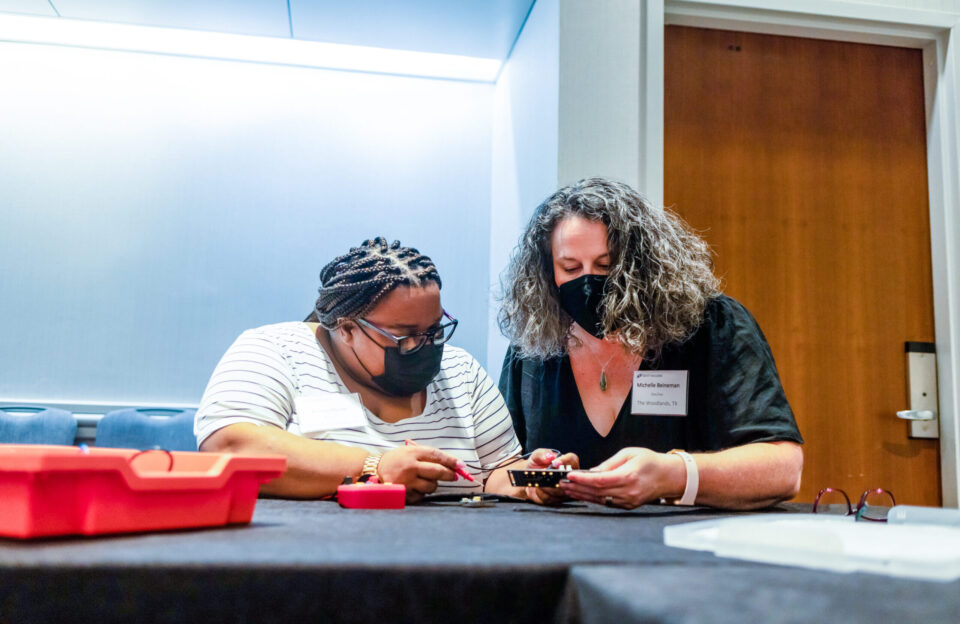 Two teachers work together on a project at the 2022 Middle School Research Teachers Conference.