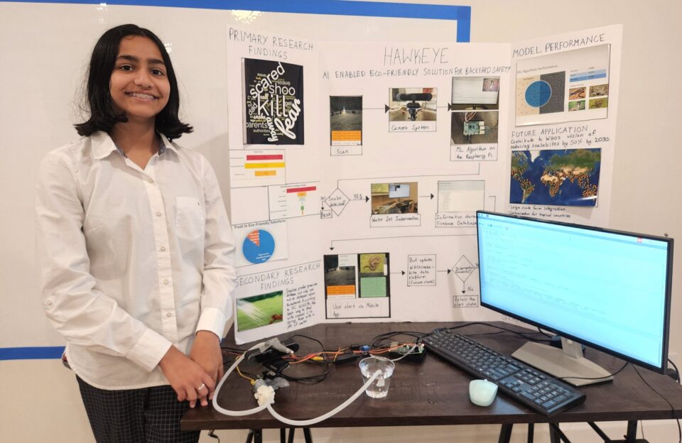 Middle School student Keertana Jillella stands in front of her poster board, displaying her research project, HawkEYE, which she received the Lemelson Early Inventor prize for.