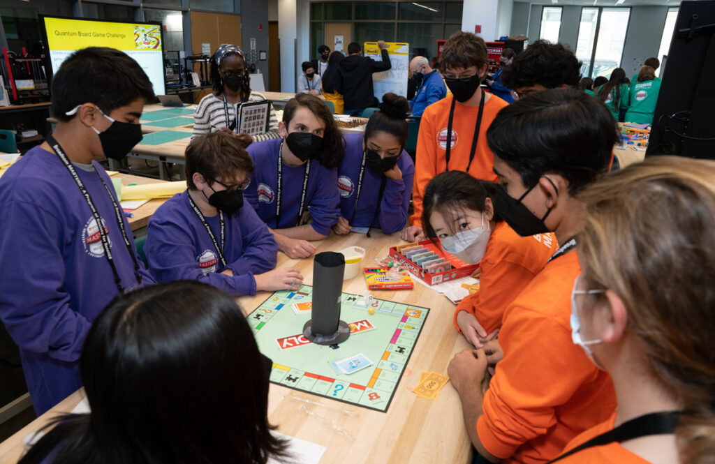 The purple and orange teams play their quantum physics board games during a challenge at George Mason University during the 2022 Broadcom MASTERS finals week.