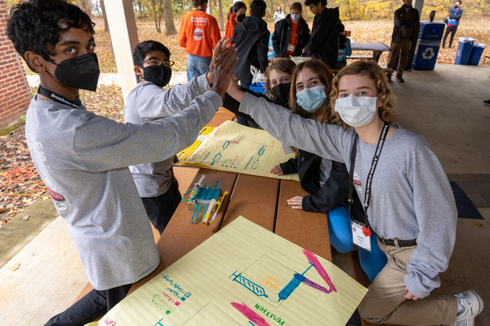 The silver team having a five-way high five after completing their prototype