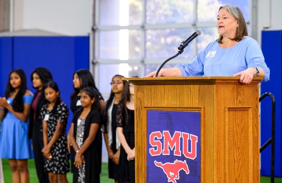 Heather Hankamer stands at a podium delivering remarks