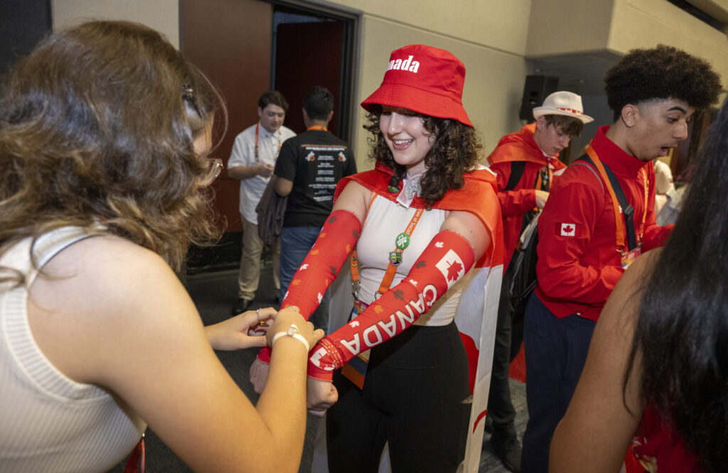 2023 Regeneron ISEF finalists show of country themed clothes during the pin exchange.