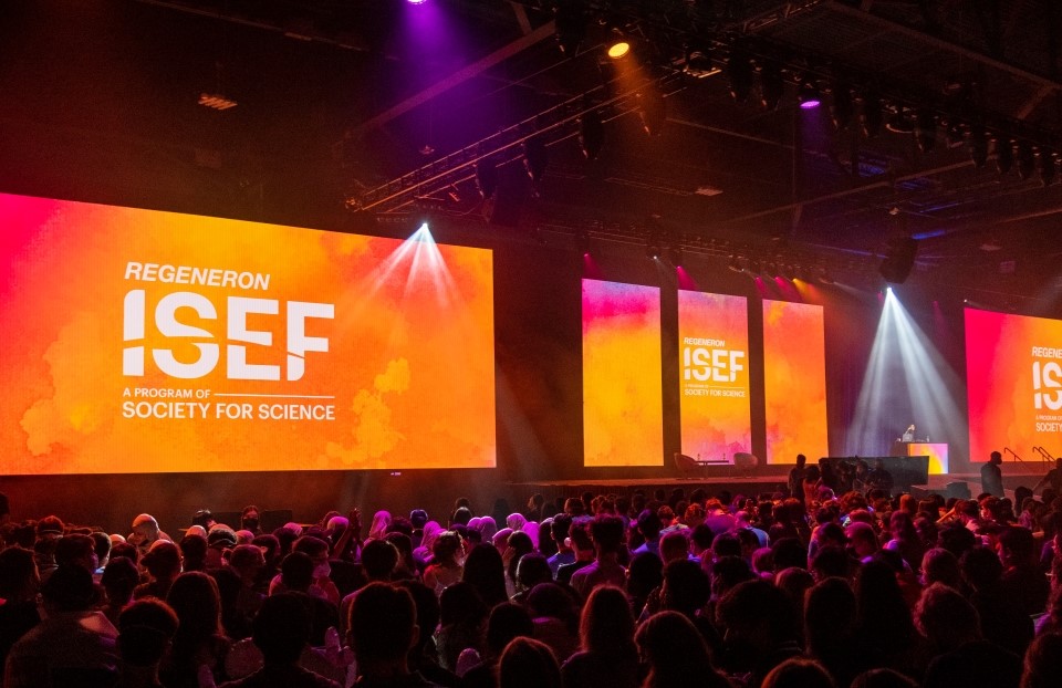 The auditorium at the Opening Ceremony of ISEF 2022. "Regeneron ISEF" is displayed on the massive screens onstage.