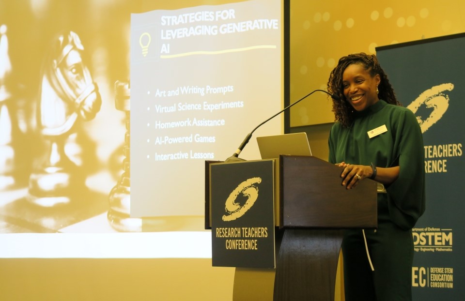 Gabriella Waters stands smiling at a podium as she delivers her remarks.