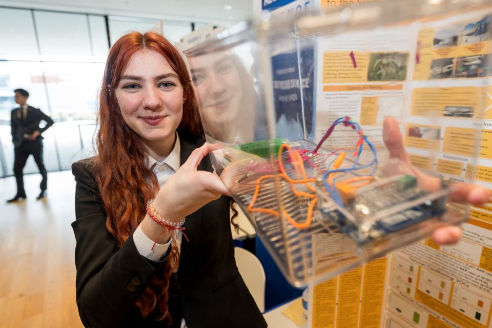 Ella Pilacek shows the box she used to help condition her bees for her project.