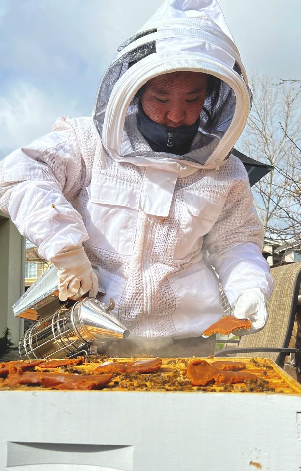 Charisse Zou tending to her bees for her project