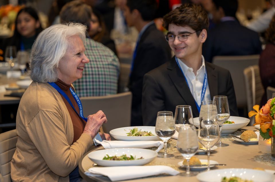 A finalist chats with another guest during the alumni dinner.