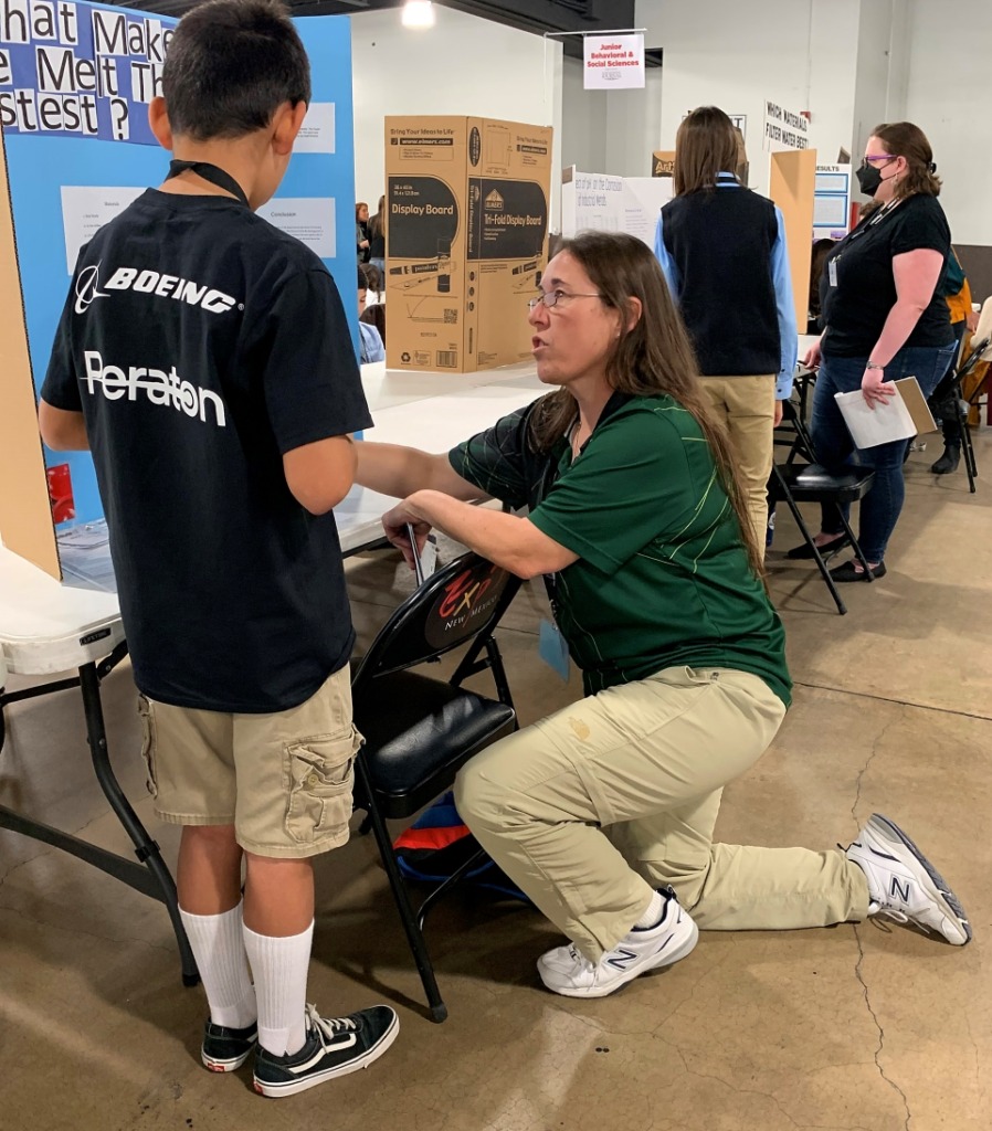 Loree helping a student at their science fair booth