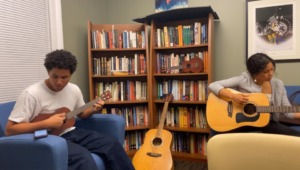 Ava Cummings (STS 2025) plays guitar at Yale's Native American Cultural Center.