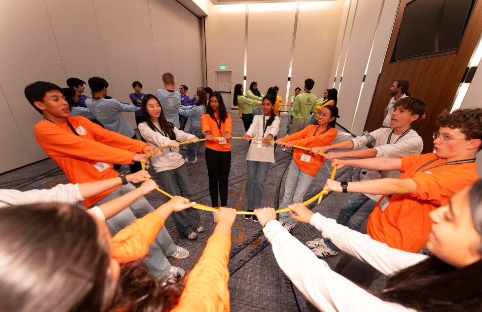 2025 JIC finalists lean backward while holding a circular rope as part of team-building activities