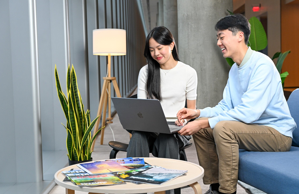 Two Regeneron STS finalists Emma Wen and Kevin Shen viewing a laptop beside a stack of Science News and Science News Explores magazines.