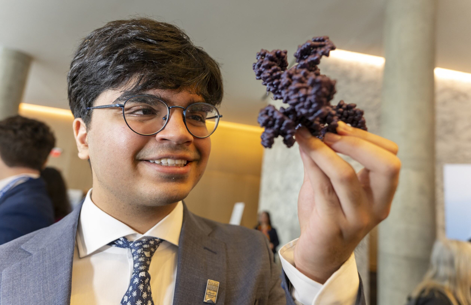 Regeneron STS 2025 finalist Sandeep Sawhney holding a large molecule in his hand at Public Day.