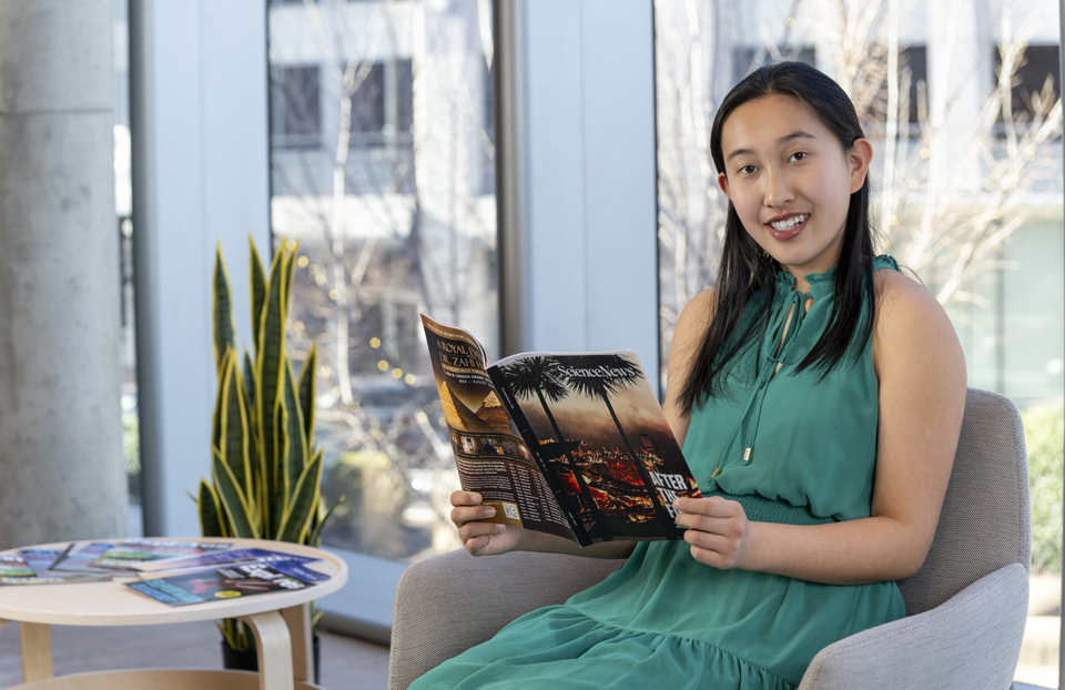 Regeneron STS 2025 finalist Jolene Cao reading a Science News magazine.