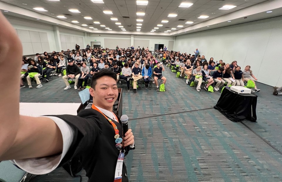 Matthew Yao taking a selfie with a room full of Education Outreach Day attendees, 2024 ISEF, Los Angeles