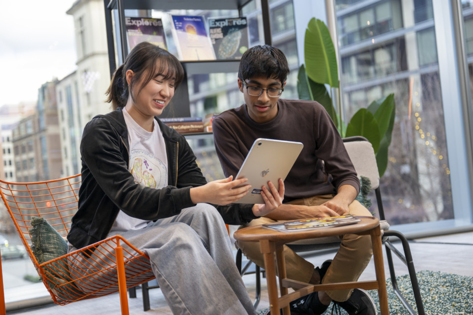 Two Regeneron STS finalists looking on a tablet at something fascinating.
