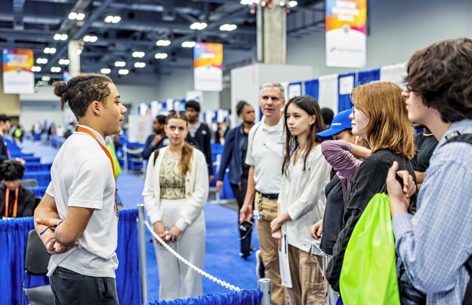 An ISEF finalist presents his research to visiting students