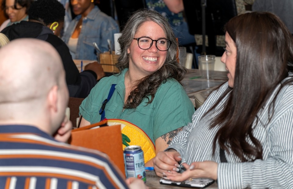 Nicolien Buholzer smiling at a table with colleagues at Regeneron ISEF 2025.