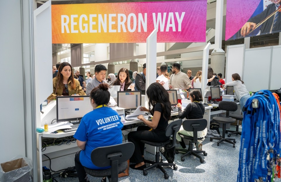 Volunteers help check in Regeneron ISEF attendees at the Registration booth.